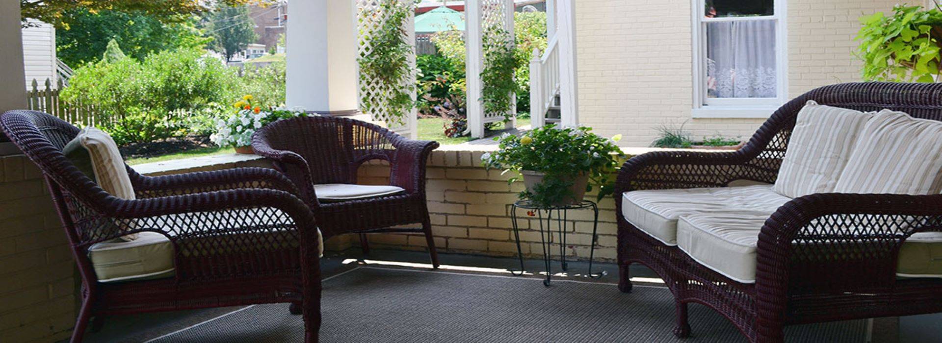 Outdoor patio with brown wicker furniture and cream cushions